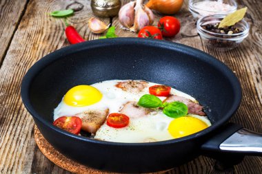 Kızarmış yumurta pastırma ve bir tavada domates ile