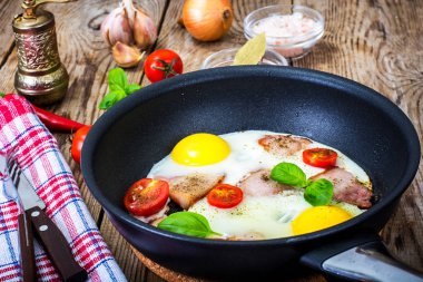Kızarmış yumurta pastırma ve bir tavada domates ile