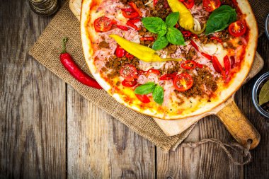 Rustik İtalyan Pizza üzerinde ince bir pasta ile kıyılmış domuz eti, jambon, Tom