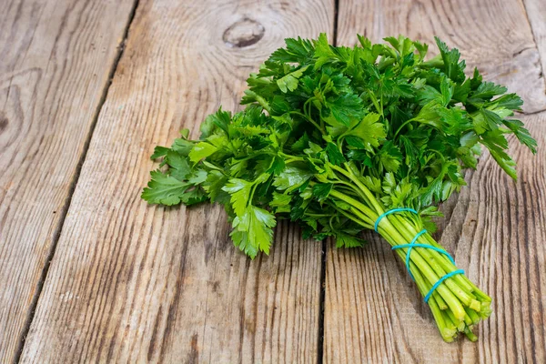 Fresh green bunch of parsley on the old board