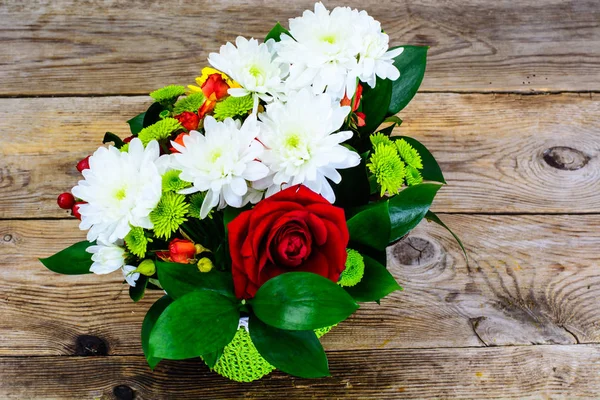 Floral arrangement of fresh flowers in the green wicker basket o — Stock Photo, Image