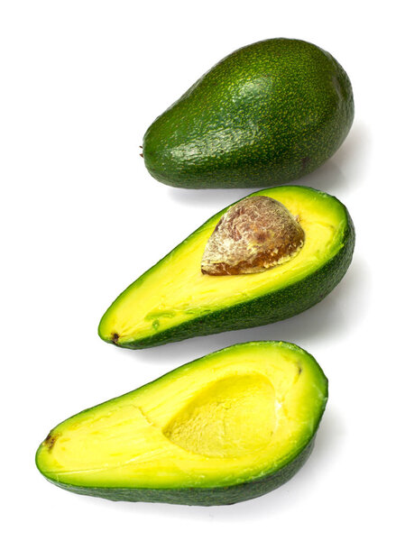 Avocado half and slices on white backgroun