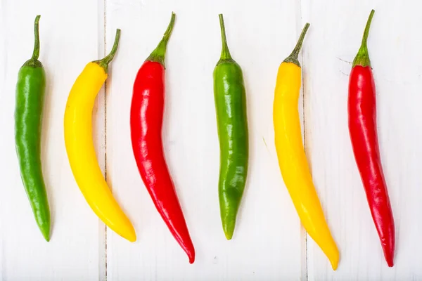 Pimentos de pimenta no fundo de madeira — Fotografia de Stock