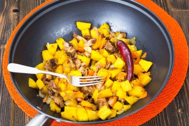 Bir tavada etli haşlanmış sebze