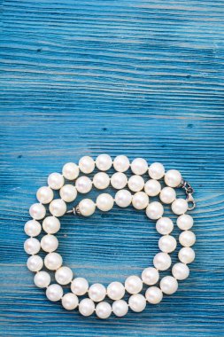 mavi bir arka plan üzerinde inci kolye