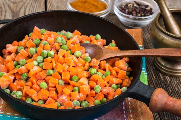Gefrorene Erbsen und Karotten zum Kochen in der Pfanne — Stockfoto