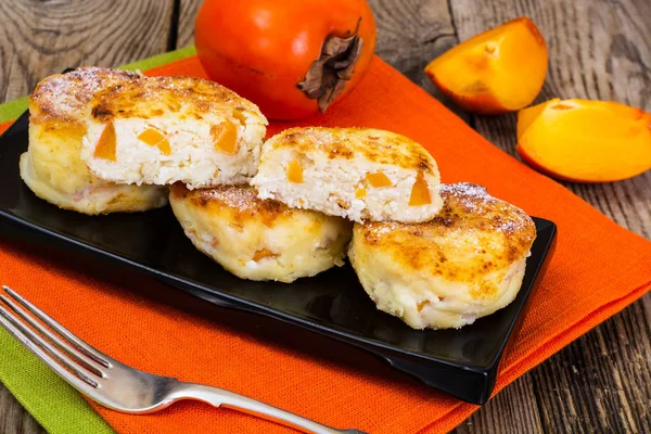 Оладьи с сыром и ломтиками хурмы на завтрак — стоковое фото
