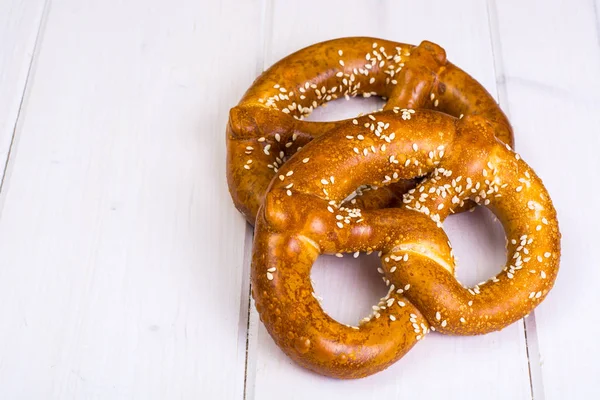 Pretzels bávaros com sementes de gergelim em placas brancas — Fotografia de Stock