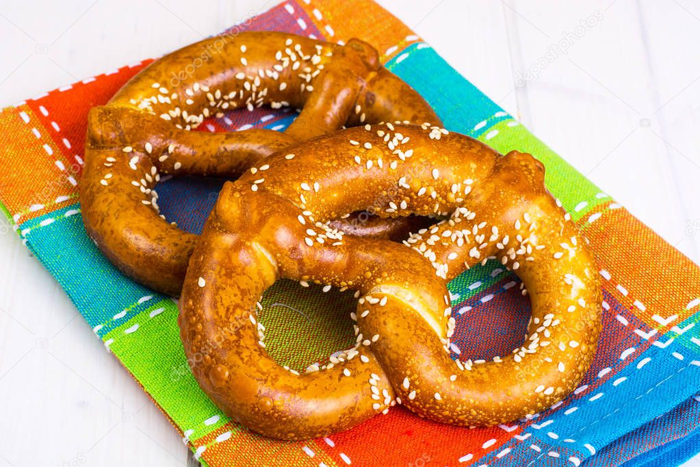 Bavarian pretzels with sesame seeds on white boards