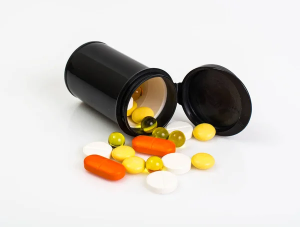 Кольорові капсули, таблетки і таблетки в пластиковій банці — стокове фото