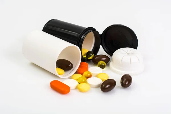 Кольорові капсули, таблетки і таблетки в пластиковій банці — стокове фото