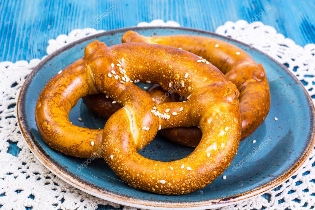 Freshly baked pretzels with salt and cheese on a blue background