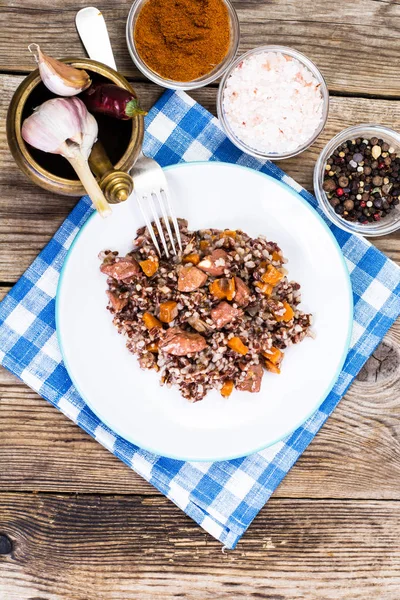 Pilaf com arroz vermelho com pedaços de carne bovina, cenoura e alho — Fotografia de Stock