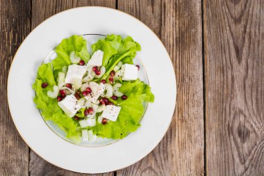 Keçi peyniri ve bir arka plan üzerinde nar yeşil salata