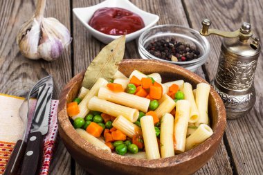 Ahşap kase yeşil bezelye ve havuç ile makarna