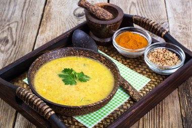 Bir tepsi ahşap bir kasede mercimek çorbası püresi