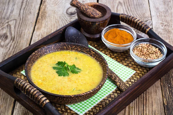 Puree soup of lentils in a wooden bowl on a tray — Stock Photo, Image