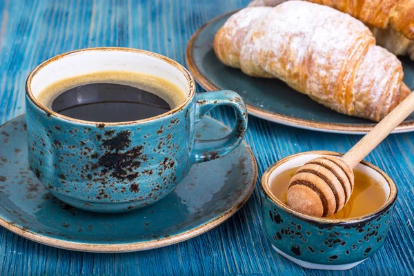 脆皮新鲜牛角包和在蓝色背景上的热咖啡 — 图库照片