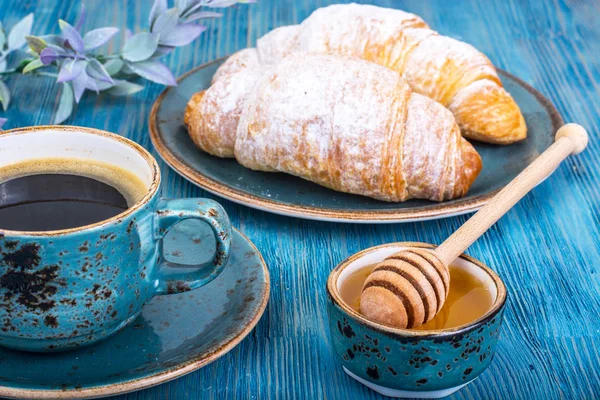 Croissant fresco crujiente y espresso caliente sobre fondo azul — Foto de Stock
