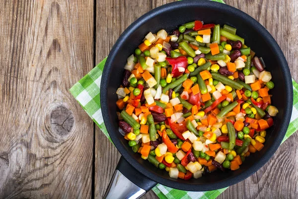 Mezcla de verduras en sartén sobre fondo de tablas viejas — Foto de Stock