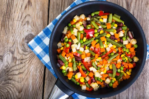 Mezcla de verduras en sartén sobre fondo de tablas viejas — Foto de Stock