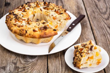 Ahşap arka plan üzerinde fındık ve kuru kayısı ile pasta