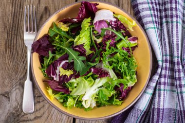 Frise, Batavi, radichchio, roka bir ahşap üzerine seramik bir kasede