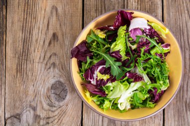 Frise, Batavi, radichchio, roka bir ahşap üzerine seramik bir kasede