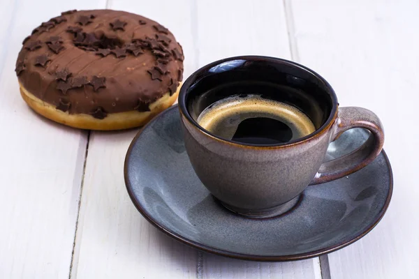 Donut with chocolate icing and espresso — Stock Photo, Image