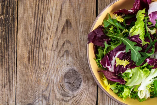 Frise, batavian, radichchio, arugula in a ceramic bowl on a wood — Stock Photo, Image