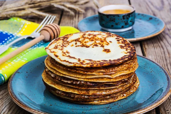 Hot pancakes with honey in vintage bowl on background of an old — Stock Photo, Image