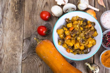 Kabak ve mantarlı ahşap arka plan üzerinde sebze güveç.