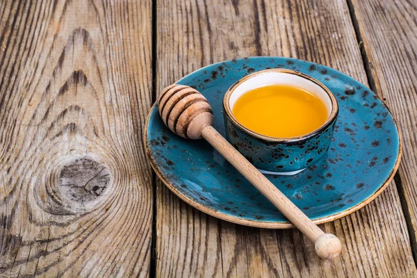 Μέλι σε Κύπελλο και κουτάλι σε φόντο ξύλινη — Φωτογραφία Αρχείου