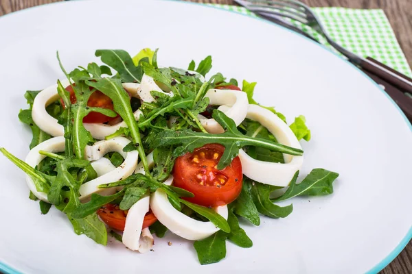 Cooked squid, fresh arugula, tomatoes, oil, spices
