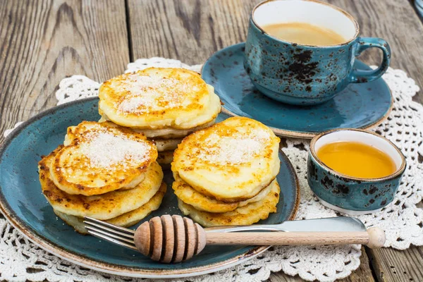 Pancakes on plate and honey in small bowl — Stock Photo, Image