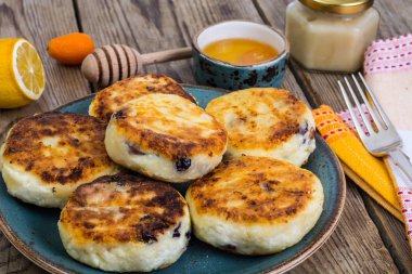 Kuru üzüm ve ahşap backgro tabakta bal ile sıcak peynirli kek