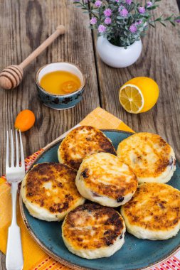 Kuru üzüm ve ahşap backgro tabakta bal ile sıcak peynirli kek