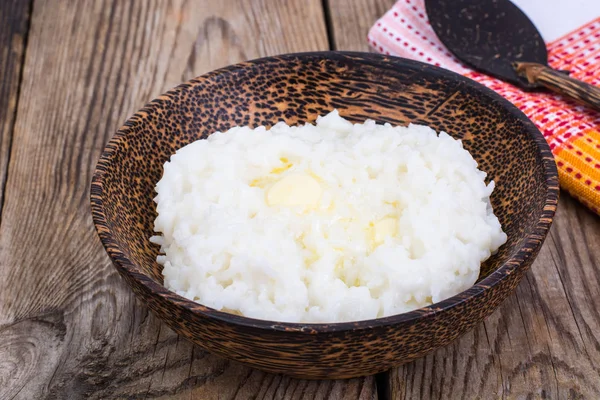 Melk rijst pap met boter in houten kom — Stockfoto