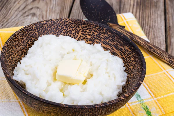 Молочная рисовая каша с маслом в деревянной миске — стоковое фото