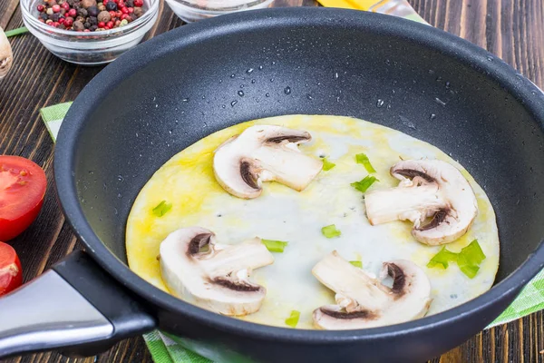 Жареные яйца с грибами в сковороде — стоковое фото