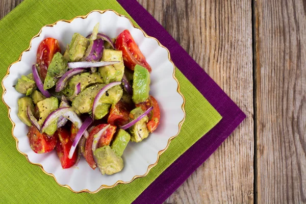 Салат с авокадо и помидорами на деревянном фоне — стоковое фото
