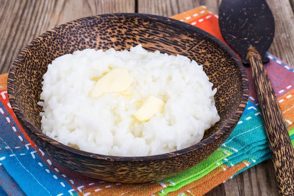 Bouillie de riz au lait avec beurre dans un bol en bois — Photo