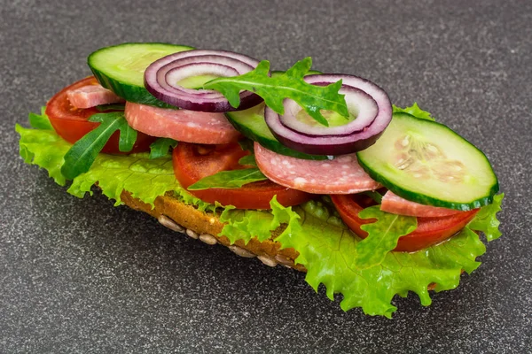 Sandwich mit Wurst und Gemüse auf Vollkornbrot — Stockfoto