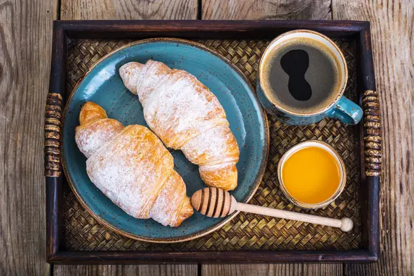 Croissant, honey and espresso in blue vintage bowl on wooden tra — Stock Photo, Image