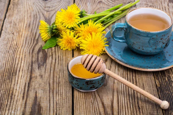 Té caliente y miel fragante de diente de león en una taza vintage azul —  Fotos de Stock