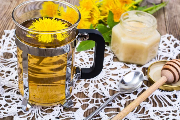 Kräutertee und Honig aus Löwenzahn auf Holzgrund. — Stockfoto