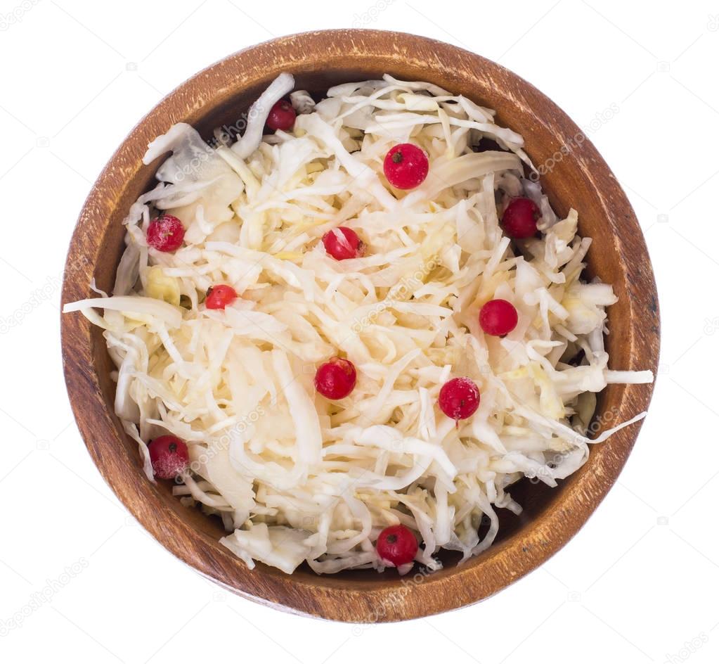 Sauerkraut with cranberries in wooden bowl on white background