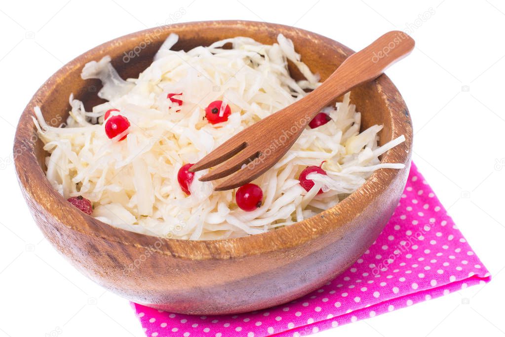 Sauerkraut with cranberries in wooden bowl on white background