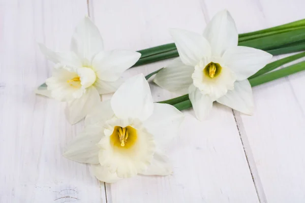 Buquê de narcisos no fundo de madeira — Fotografia de Stock