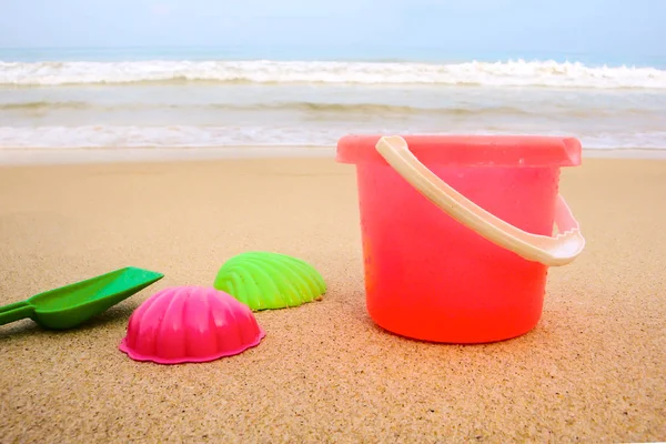 Childrens pail and colored molds on the beach in the sand